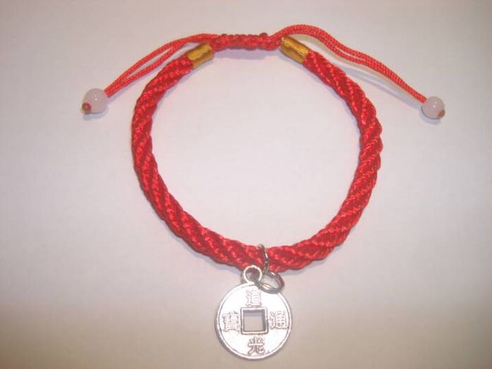 Red thread bracelet with a rare coin to attract luck